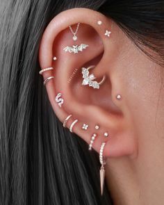 a woman wearing ear piercings with different designs