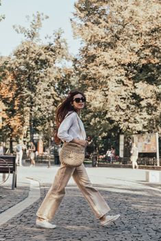 a woman walking down the street carrying a purse