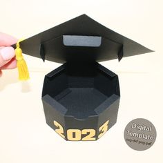 someone is holding a graduation hat out of an origami box