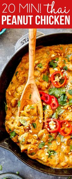 a skillet filled with chicken and vegetables on top of a wooden spoon in it