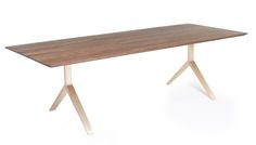 a wooden table sitting on top of a white floor next to a metal cross leg