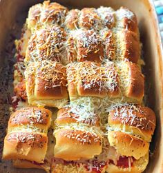 a casserole dish filled with different types of breads and cheese sprinkled on top