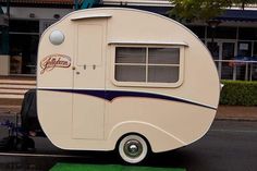 an rv is parked on the side of the road in front of a storefront