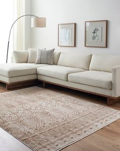 a living room with a white couch and beige rug