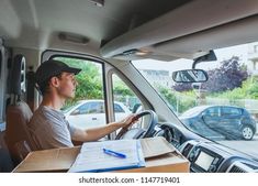 a man sitting in the driver's seat of a moving truck