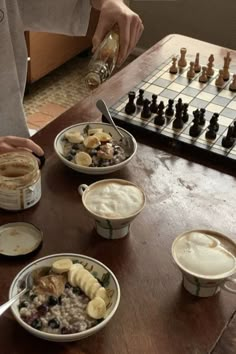 a man sitting at a table with cups of coffee and bowls of food in front of him