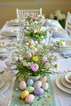 an easter table setting with flowers and eggs