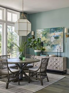 a dining room table with chairs and a potted plant