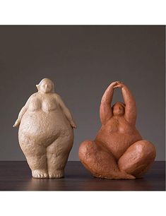 two ceramic sculptures sitting next to each other on a table