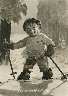 an old black and white photo of a child with skis