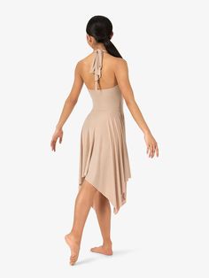 a woman in a tan dress is dancing