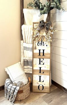 a wooden sign that says oh hello next to a basket with towels on it