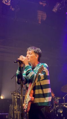 a man standing in front of a microphone on top of a stage