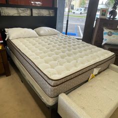 a mattress and foot stool in a store