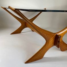 a wooden table with glass top and curved legs