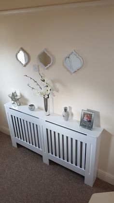 a white radiator sitting next to a wall with pictures and flowers on it