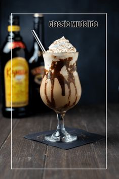 an ice cream sundae with chocolate sauce and whipped cream on top, next to bottles of booze