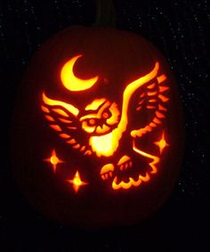 a carved pumpkin with an owl and stars on it's face in the dark