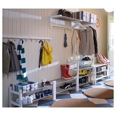 a white coat rack filled with coats and shoes next to a checkered floor in a room