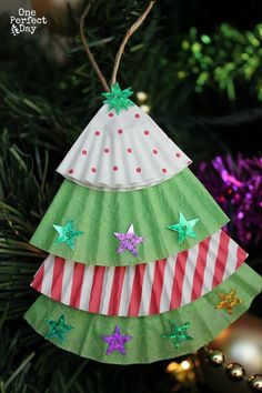 a paper christmas tree ornament hanging from a christmas tree