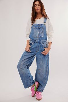 a woman wearing overalls and pink shoes