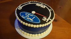 a ford car speedometer cake on a wooden table with the word ford written on it