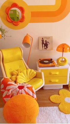 an orange and yellow living room with white rugs on the wooden floor, two chairs in front of a wall decorated with flowers