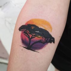 a small tattoo on the arm of a person with a sunset in the back ground