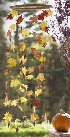 an autumn mobile with leaves and acorns hanging from it