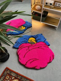 two rugs on the floor in front of a potted plant and a mirror