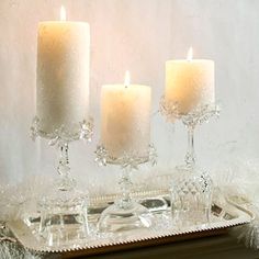 three white candles are sitting on a tray