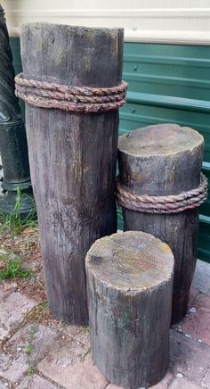 three wooden logs sitting on top of a brick sidewalk