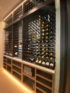 a wine cellar filled with lots of bottles of wine on shelves next to a wall