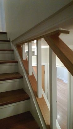 an empty room with stairs and hard wood flooring on the side of the wall