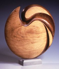 a wooden sculpture sitting on top of a white table