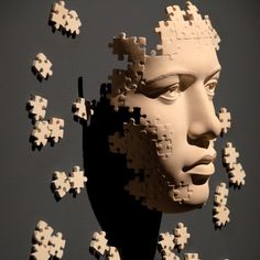 a sculpture made out of pieces of puzzles with a man's face in the middle