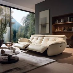 a living room filled with furniture next to a large glass window overlooking a forest covered hillside