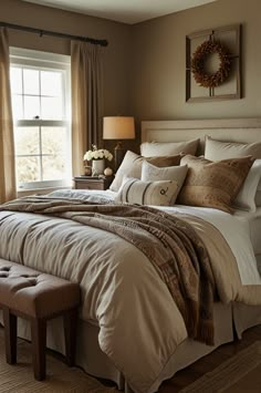 a large bed sitting in a bedroom next to a window covered in pillows and blankets