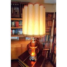 a lamp that is sitting on top of a book shelf in front of a bookshelf