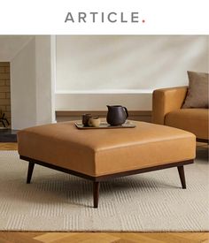 a coffee table sitting on top of a rug in front of a chair and ottoman