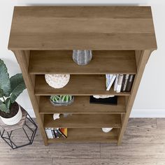 a book shelf with books and plants on it