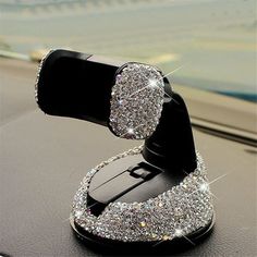 a cell phone holder that is sitting on top of a car dashboard with sparkling diamonds