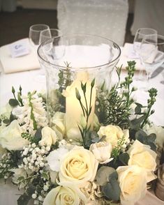 a centerpiece with candles and flowers on a table