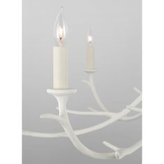 two candles are lit on a white chandelier