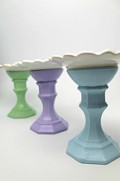 three different colored vases sitting next to each other on top of a white table