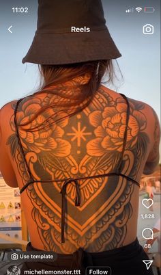 the back of a woman's body with tattoos on it