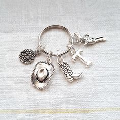 a silver keychain with charms on it sitting on top of a white cloth