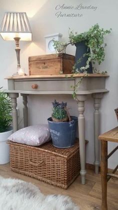 a table with some plants on top of it next to a basket and lamp in the corner