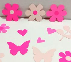 pink and white paper cut outs with hearts, flowers and butterflies in the shape of heart shapes