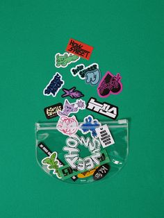 various stickers in a clear pouch on a green surface, with the word love written below them